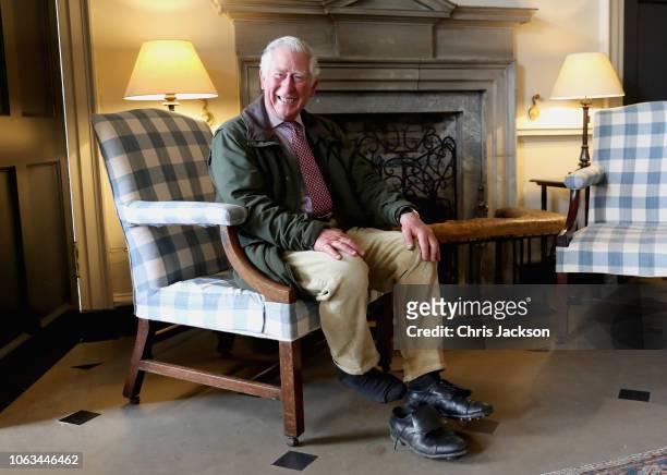 Prince Charles, Prince of Wales laughs as he takes off his boots after an afternoon walk around the grounds of Dumfries House on May 3, 2018 in...