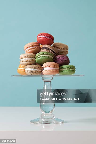 macaroon cookies on teal background - cakestand stock-fotos und bilder