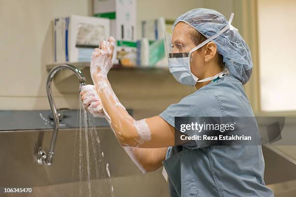 surgical nurse scrubs her hands - surgery preparation stock pictures, royalty-free photos & images