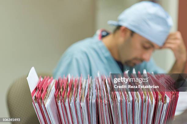 nurse with patient files in foreground - nurse paperwork stock pictures, royalty-free photos & images