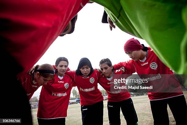 Members of the Afghan women's national football team huddles during a match with the NATO-led International Security Assistance Force women's team in...