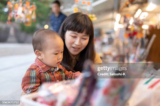 幼い息子の土産物店で母親とショッピング - baby products ストックフォトと画像