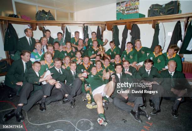Springboks captain Francois Pienaar holds the trophy as his team mates celebrate in the dressing room after their 1995 Rugby World Cup Final victory...