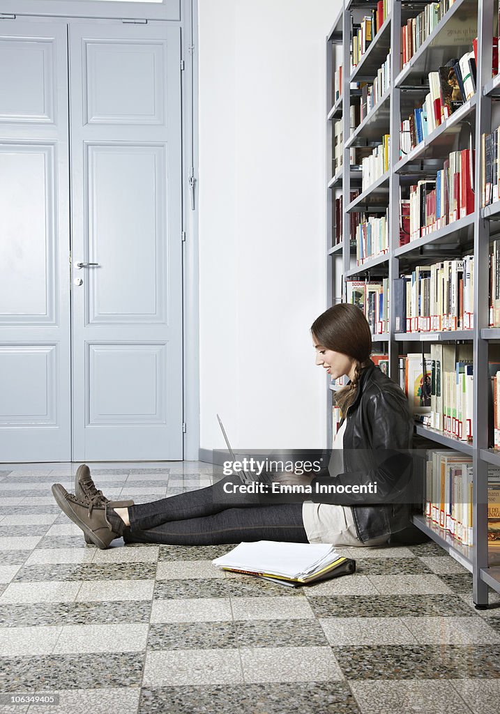 Student sitting on the floor of library studying