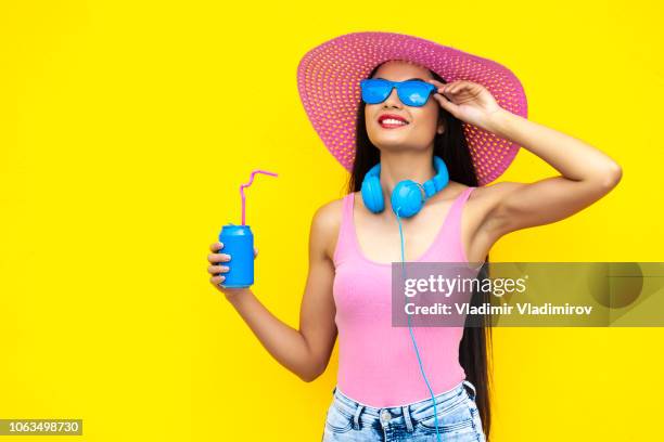 lächelnde frau mit rosa hut blau dose zu halten - frau sommerlich studioaufnahme stock-fotos und bilder