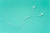 Earphones for Smartphone on Turquoise Background Top View
