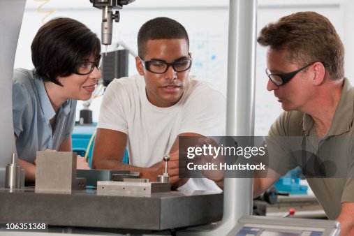 Engineering Instructor Engineering Professor Demonstrating A Coordinate Measuring Machine To ...