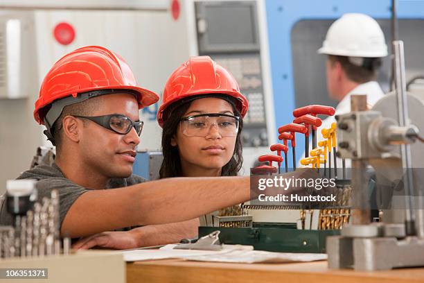 engineering students selecting drill bits for a cnc machine - work helmet stock pictures, royalty-free photos & images