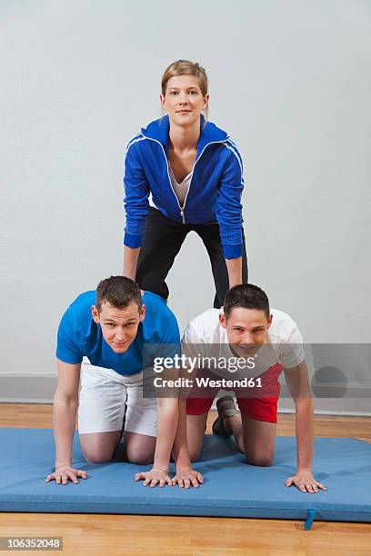germany, berlin, young men and women building human pyramid, portrait - male gymnast stock pictures, royalty-free photos & images