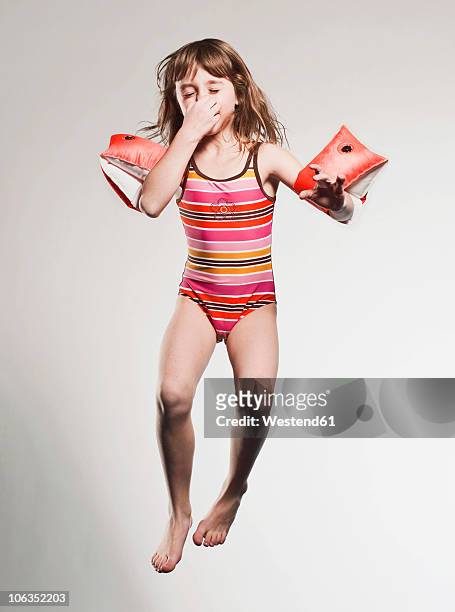 girl (7-8) wearing armband and jumping - brazaletes acuáticos fotografías e imágenes de stock