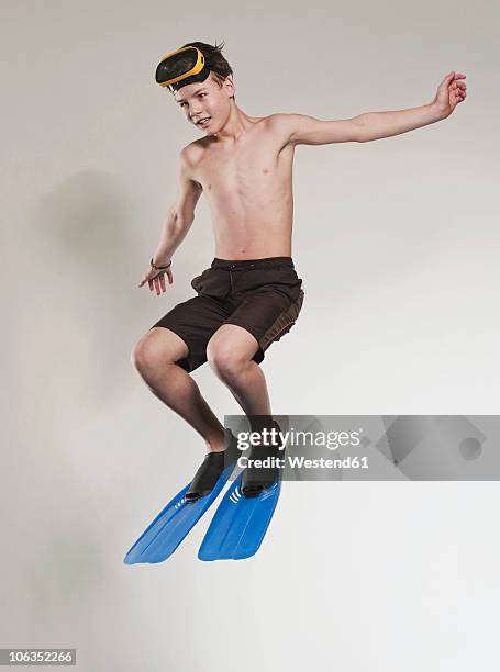 boy (12-13) wearing diving outfit and jumping - zwemvliezen stockfoto's en -beelden