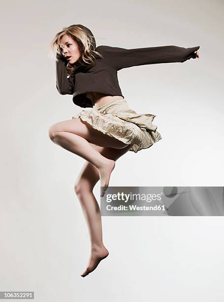 woman jumping against gray background - skirt isolated stock pictures, royalty-free photos & images