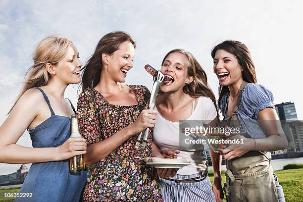 germany, cologne, women enjoying beer and sausages - beer bottle mouth stock pictures, royalty-free photos & images