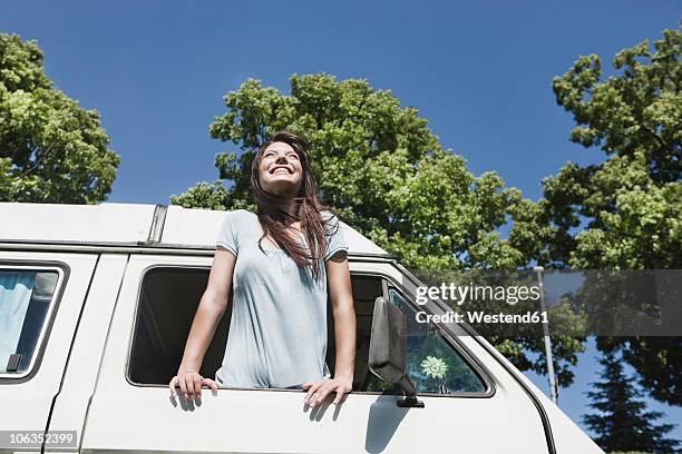 germany, cologne, young woman smiling - camping bus stock-fotos und bilder
