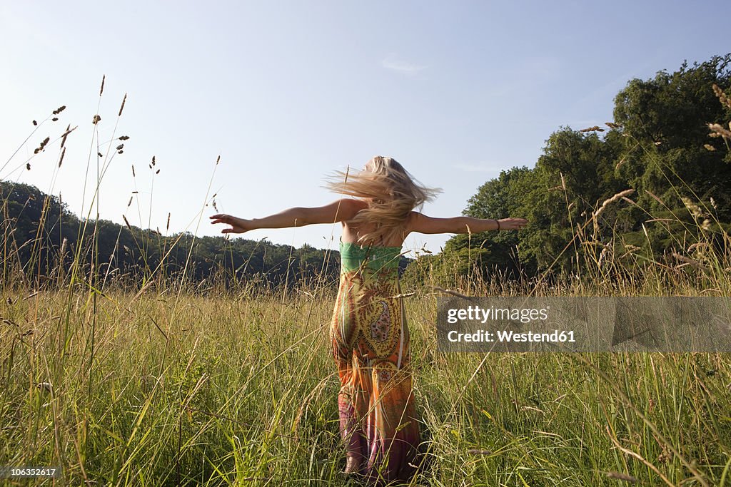 Germany, Dortmund, Young woman turning and having fun