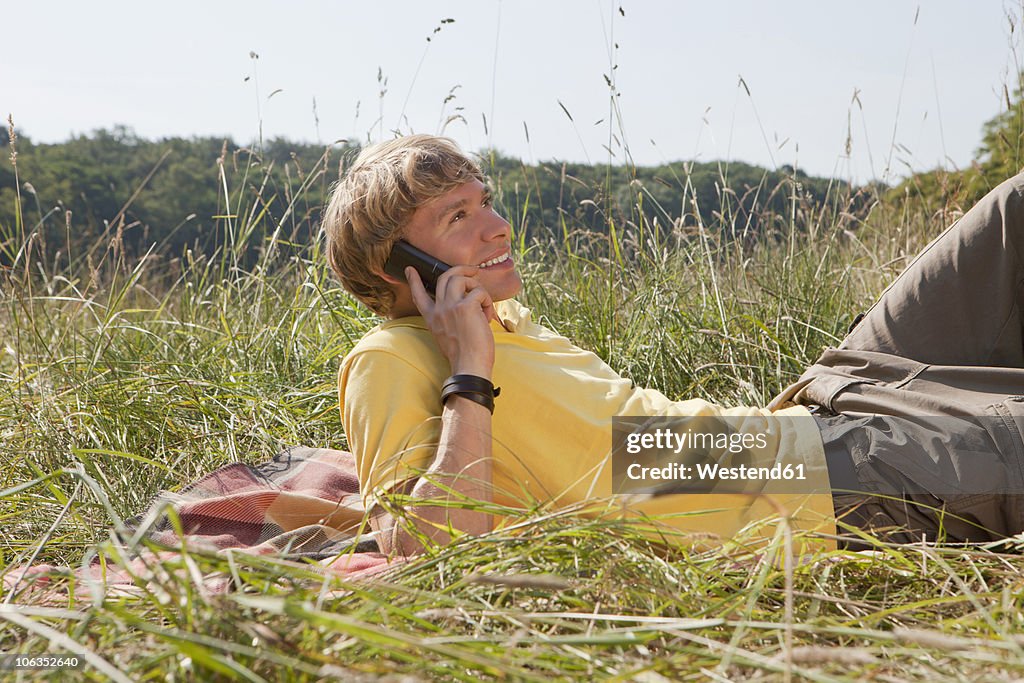 Germany, Dortmund, Young man on the phone, smiling