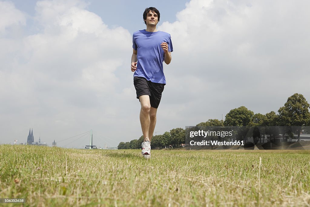 Germany, Cologne, Young man jogging