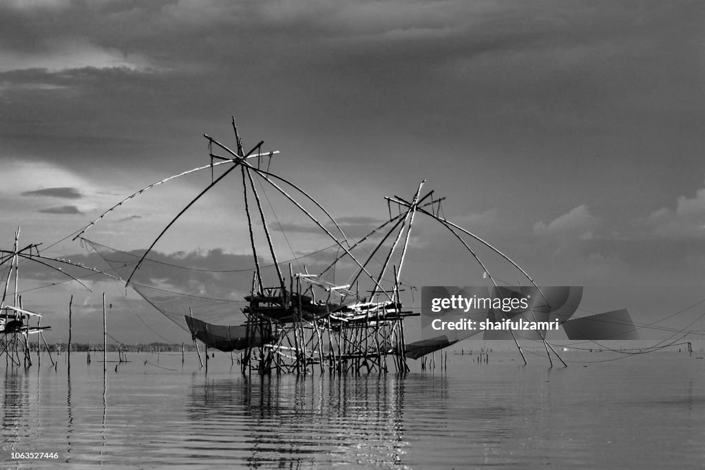 Traditional fishing nets made from bamboo and wood over cloudy sunrise at lake Thale Noi, Phatthalung, Thailand.