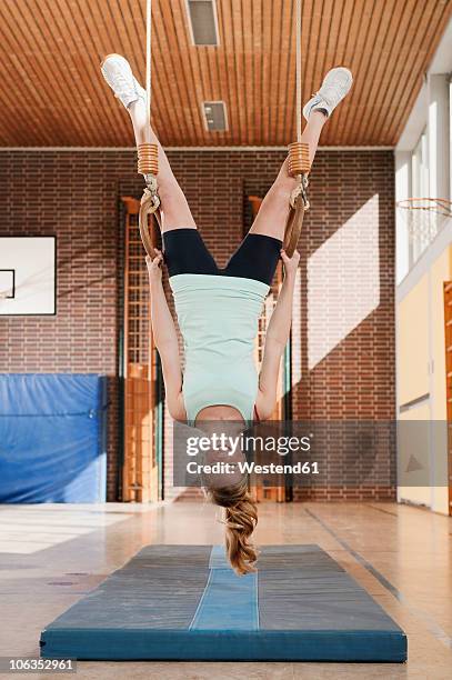 germany, emmering, girl hanging from flying rings, smiling, portrait - school gymnastics 個照片及圖片檔