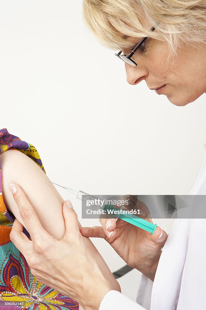 Germany, Munich, Doctor injecting girl (8-9)