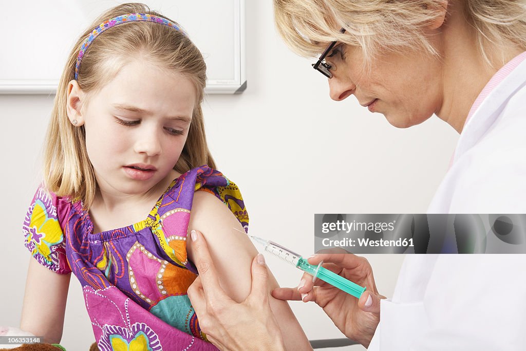 Germany, Munich, Doctor injecting girl (8-9)