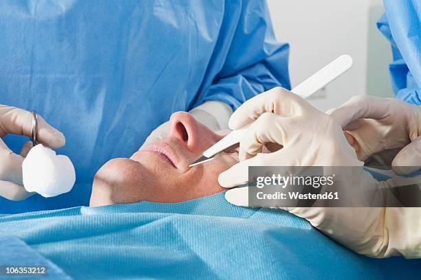 germany, munich, surgeons performing operation - cirugía plástica hombres fotografías e imágenes de stock