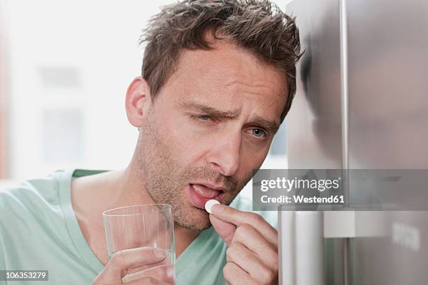 germany, man taking medicine, close up - the morning after stock pictures, royalty-free photos & images