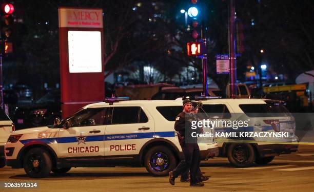 Chicago Police officers monitor the area outside of the Chicago Mercy Hospital where a gunman opened fire in Chicago on November 19, 2018. - An...