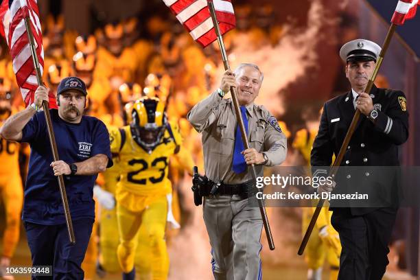 Ventura County Fire, California Highway Patrol and Los Angeles Fire Department members carry flags onto the field before the start of the game...