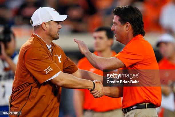 Head coach Tom Herman of the Texas Longhorns shakes hands with head coach Mike Gundy of the Oklahoma State Cowboys on October 27, 2018 at Boone...