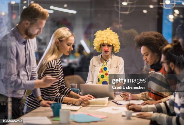 payaso de negocios con ordenador portátil en una reunión con sus colegas. - payaso fotografías e imágenes de stock