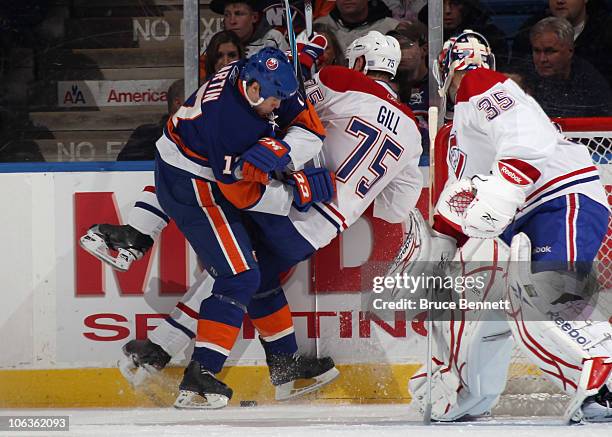 Hal Gill of the Montreal Canadiens is hit by Matt Martin of the New York Islanders at the Nassau Coliseum on October 29, 2010 in Uniondale, New York.