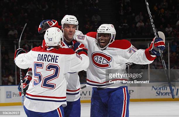 Mathieu Darche, Benoit Poulin and P.K. Subban of the Montreal Canadiens celebrate Poulin's game winning goal against the New York Islanders at the...