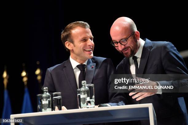 Belgian Prime Minister Charles Michel and French President Emmanuel Macron share a laugh during their visit at the University of Louvain on November...