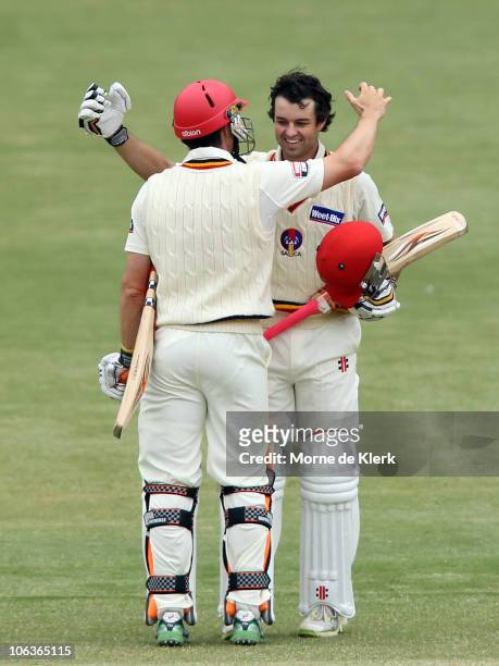 Callum Ferguson of the Redbacks celebrates making 100 runs with team mate Michael Klinger during day two of the Sheffield Shield match between the...