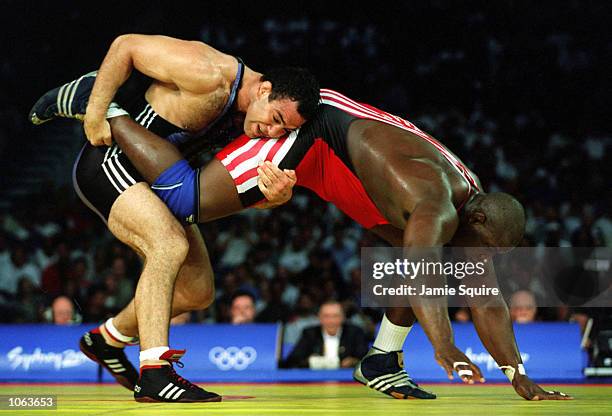 Alexis Rodriguez of Cuba is held by Krassimir Kotchev of Bulgaria during the 130 kilogram Freestyle wrestling event held at the Sydney Convention and...