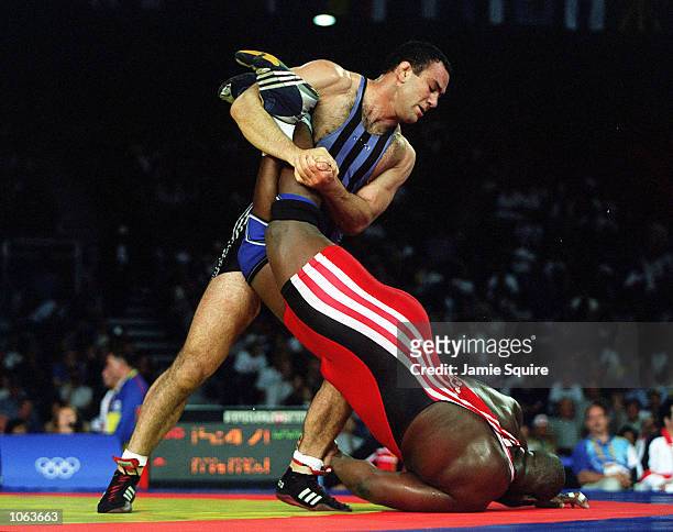 Alexis Rodriguez of Cuba is held by Krassimir Kotchev of Bulgaria during the 130 kilogram Freestyle wrestling event held at the Sydney Convention and...