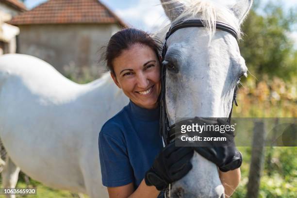 woman hugging horse - racehorse owner stock pictures, royalty-free photos & images