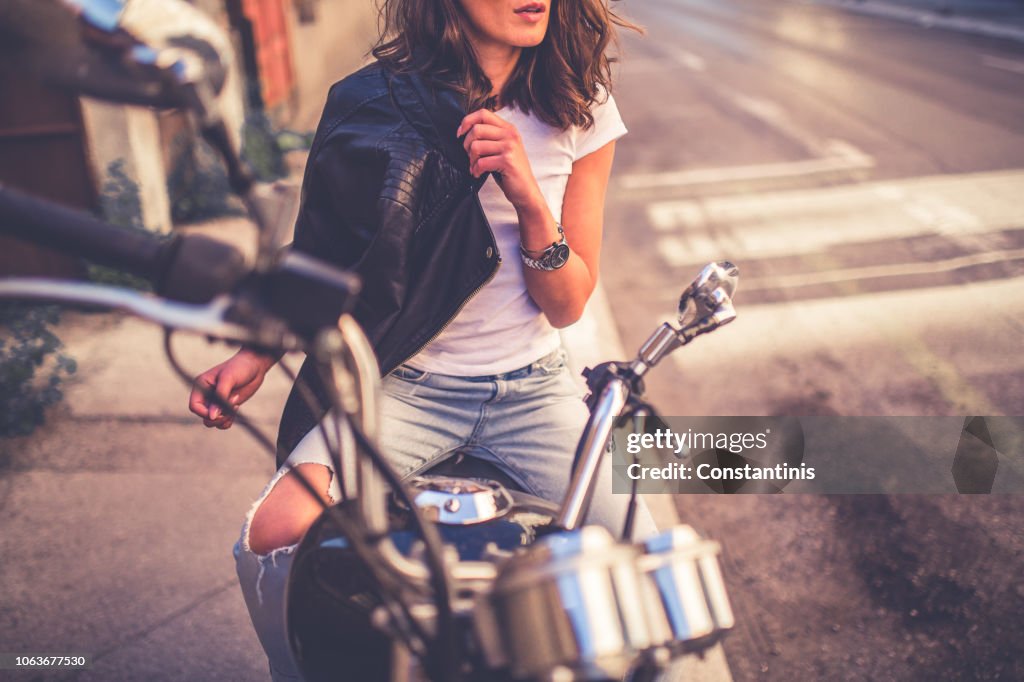 Giovane ragazza piuttosto modellata seduta sulla sua moto