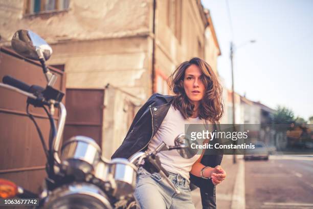 bonita moda joven sentado en su motocicleta - women black and white motorcycle fotografías e imágenes de stock