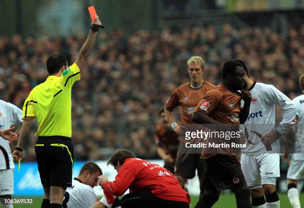 Referee Volker Wenzel shows Gerald Asamoah of St. Pauli the yellow red card during the Bundesliga match between FC St. Pauli and Eintracht Frankfurt...