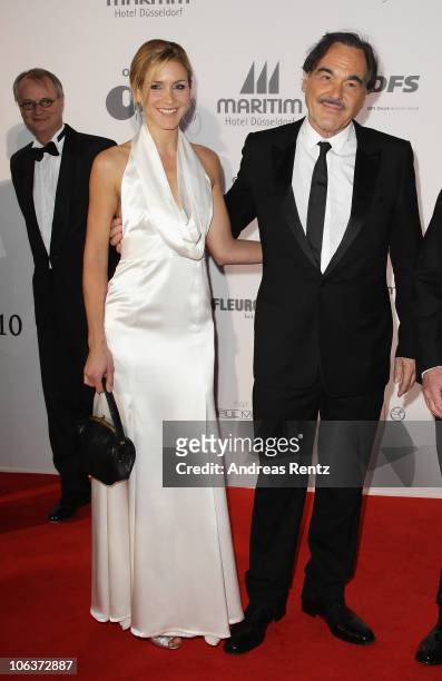 Director Oliver Stone and Florine Elena Deplazes arrive for the UNESCO Charity-Gala 2010 at Maritim Hotel on October 30, 2010 in Duesseldorf, Germany.