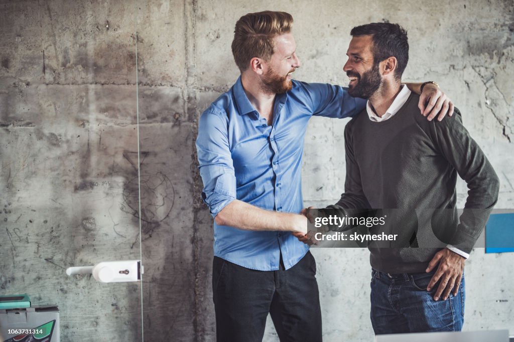 Glücklich Geschäftsleute Gruß einander im Büro.