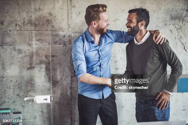 gelukkig zakenlieden begroeten elkaar op het kantoor. - positieve emotie stockfoto's en -beelden
