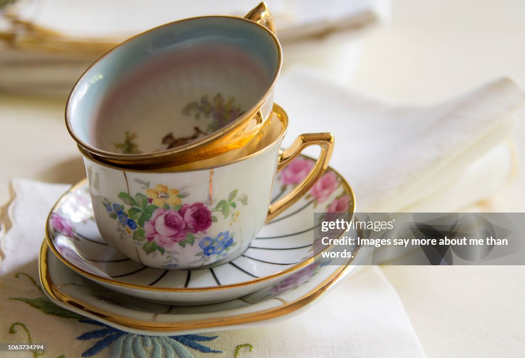 Two antique porcelain tea cups over a light background. Still life.