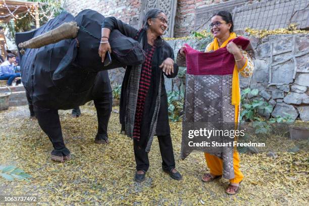 Gurpreet Sidhu, founder of The People Tree boutique shares a laugh with one of her designers in the yard of their shop in Champa Gali, New Delhi,...