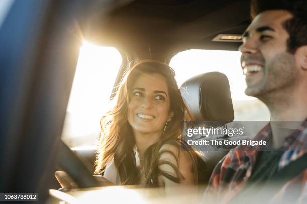 happy couple driving in car on road trip - happy couple car fotografías e imágenes de stock