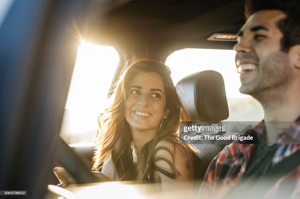 Happy couple driving in car on road trip