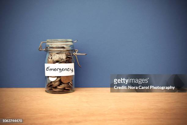 coins jar for emergency savings - emergencies and disasters stock pictures, royalty-free photos & images