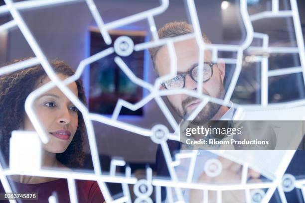 business people looking at a futurisitic digitally generated display - globe navigational equipment stock-fotos und bilder